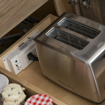A Roll-out Shelf with charging station outlet for small kitchen appliances and clutter free counters.